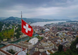 Aerial shot of swizz flag waving over lucerne